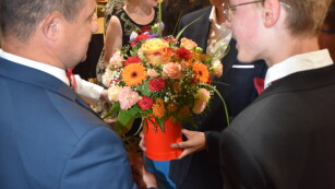 Pan Wicedyrektor odbiera kwiaty z rąk uczniów