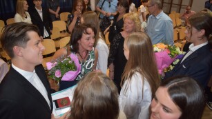 Uczniowie wręczają kwiaty nauczycielce